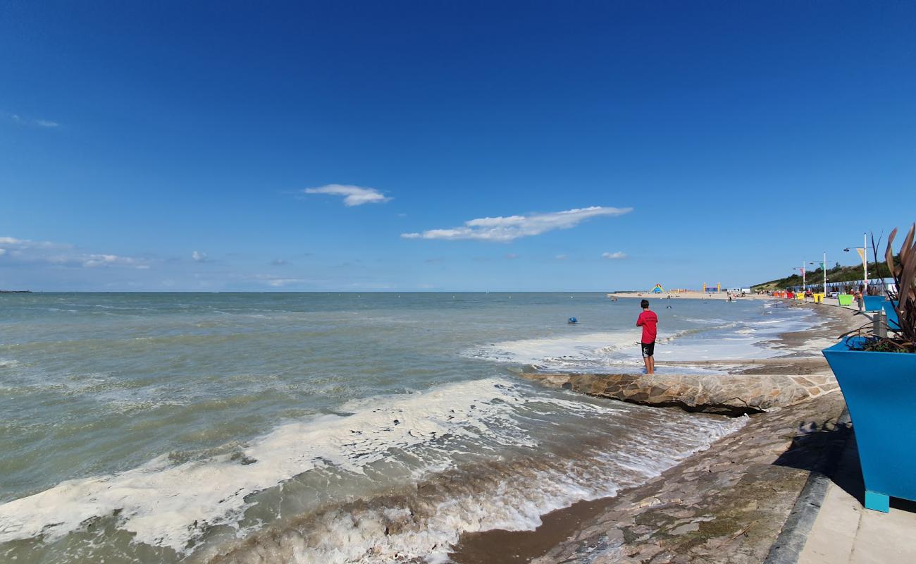 Petit-Fort-Philippe Beach'in fotoğrafı kahverengi kum yüzey ile