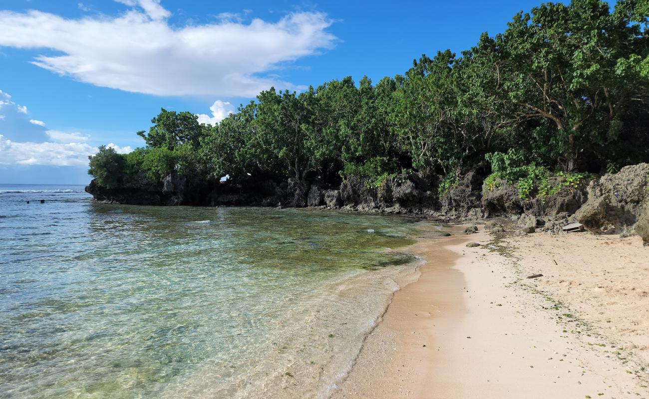 Tanguisson Beach'in fotoğrafı parlak kum ve kayalar yüzey ile