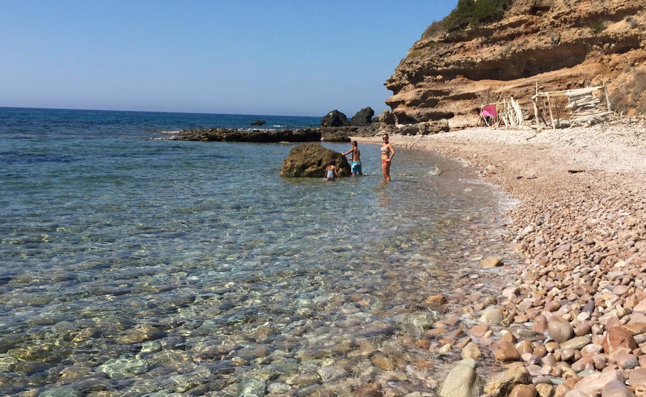 Cala Salto del Cervo'in fotoğrafı gri çakıl taşı yüzey ile