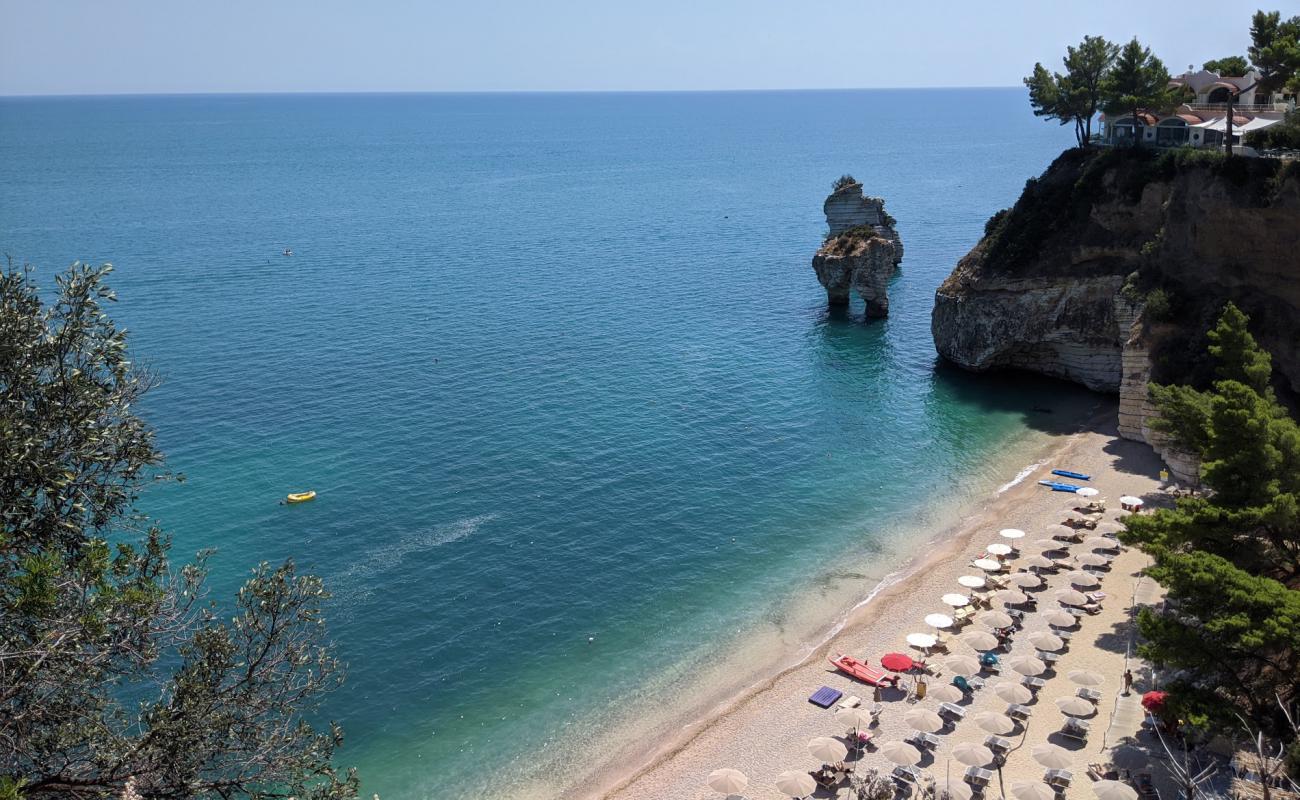 Faraglioni Plajı'in fotoğrafı bej kum ve çakıl yüzey ile