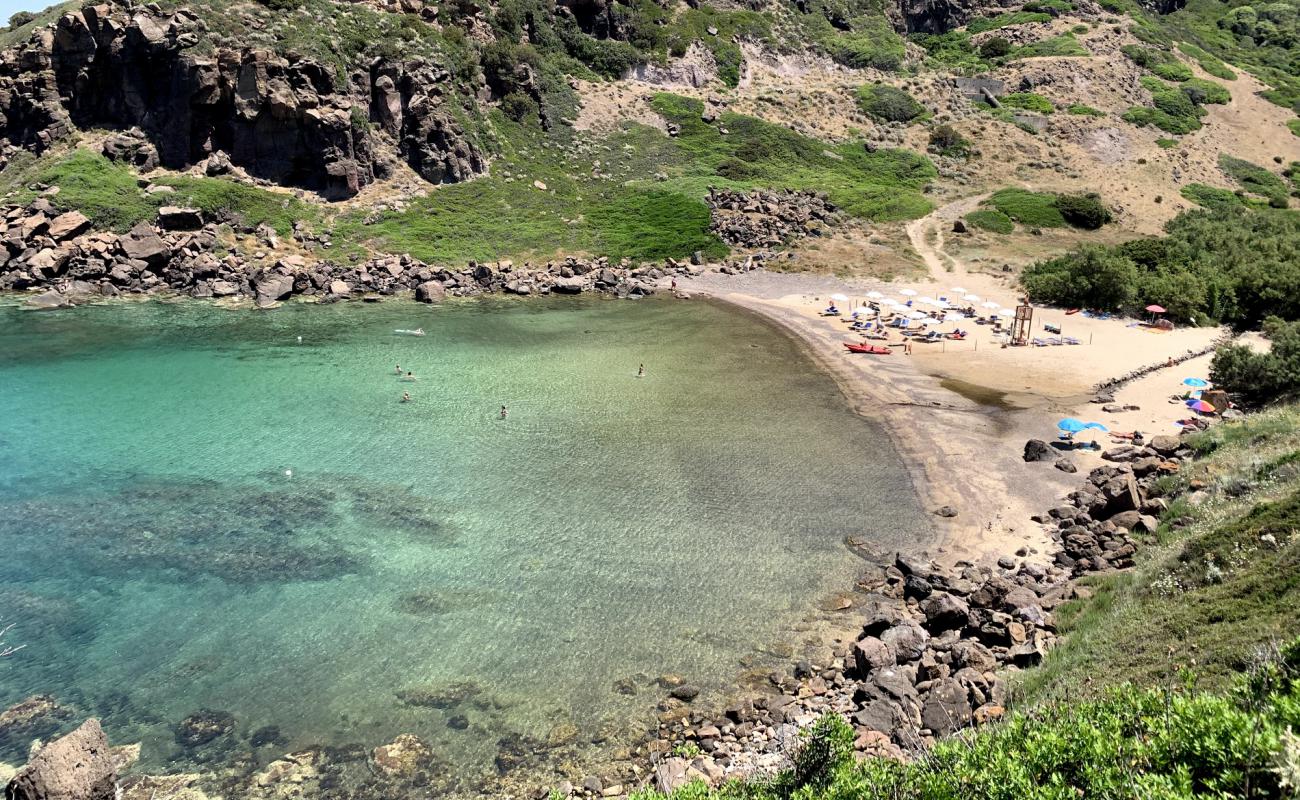Cala Ostina'in fotoğrafı siyah kum ve çakıllar yüzey ile