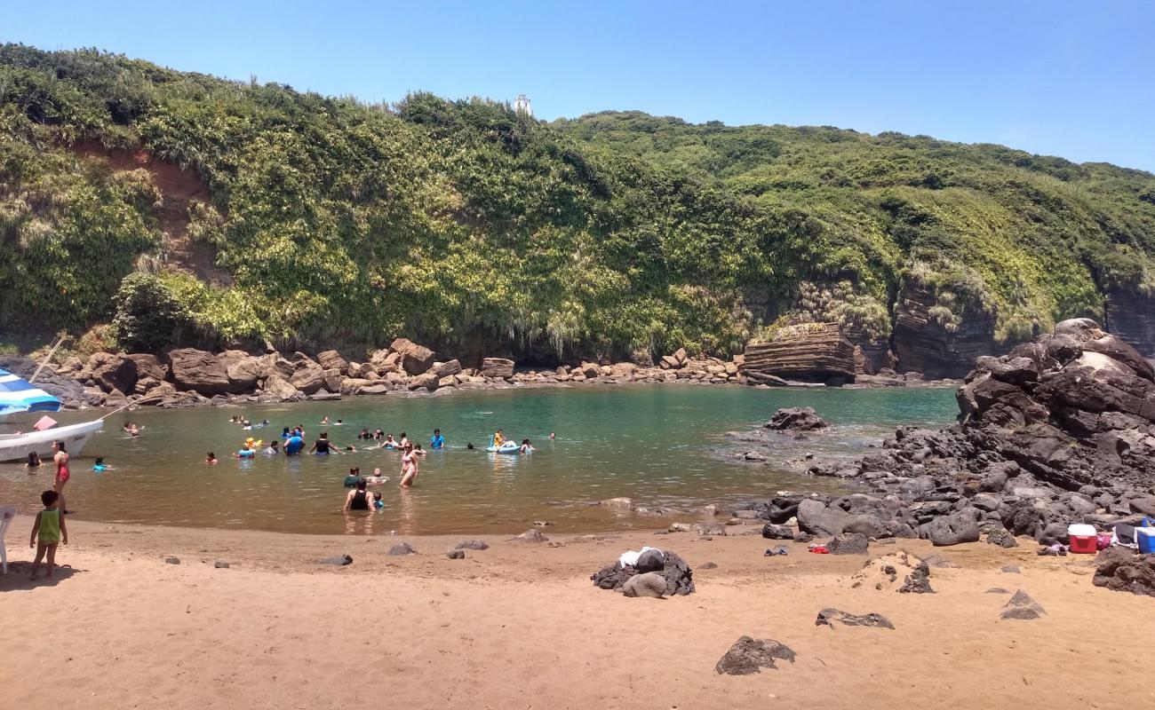 Playa Escondida'in fotoğrafı bej kum ve kayalar yüzey ile