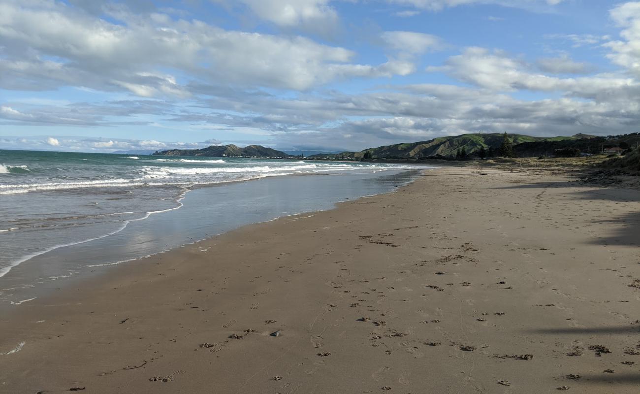 Okitu Beach'in fotoğrafı açık bej kum yüzey ile