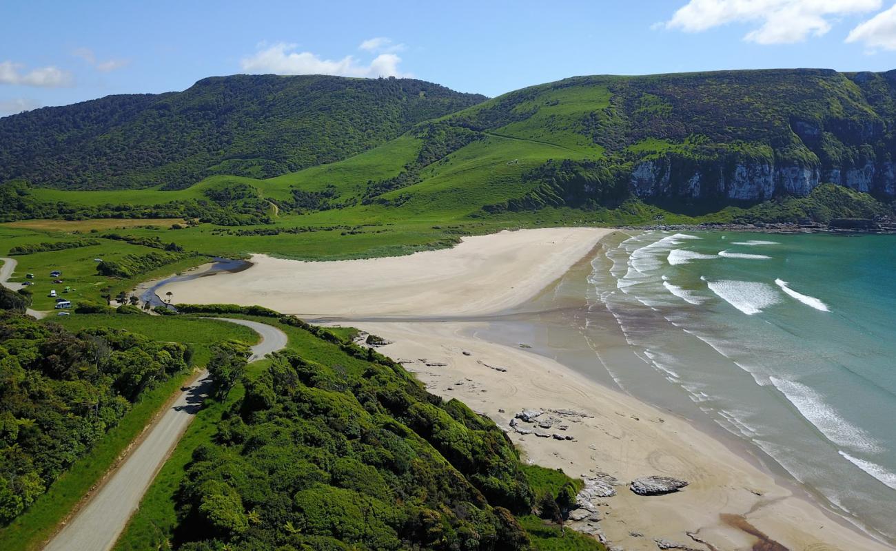 Purakaunui Bay Beach'in fotoğrafı açık bej kum yüzey ile