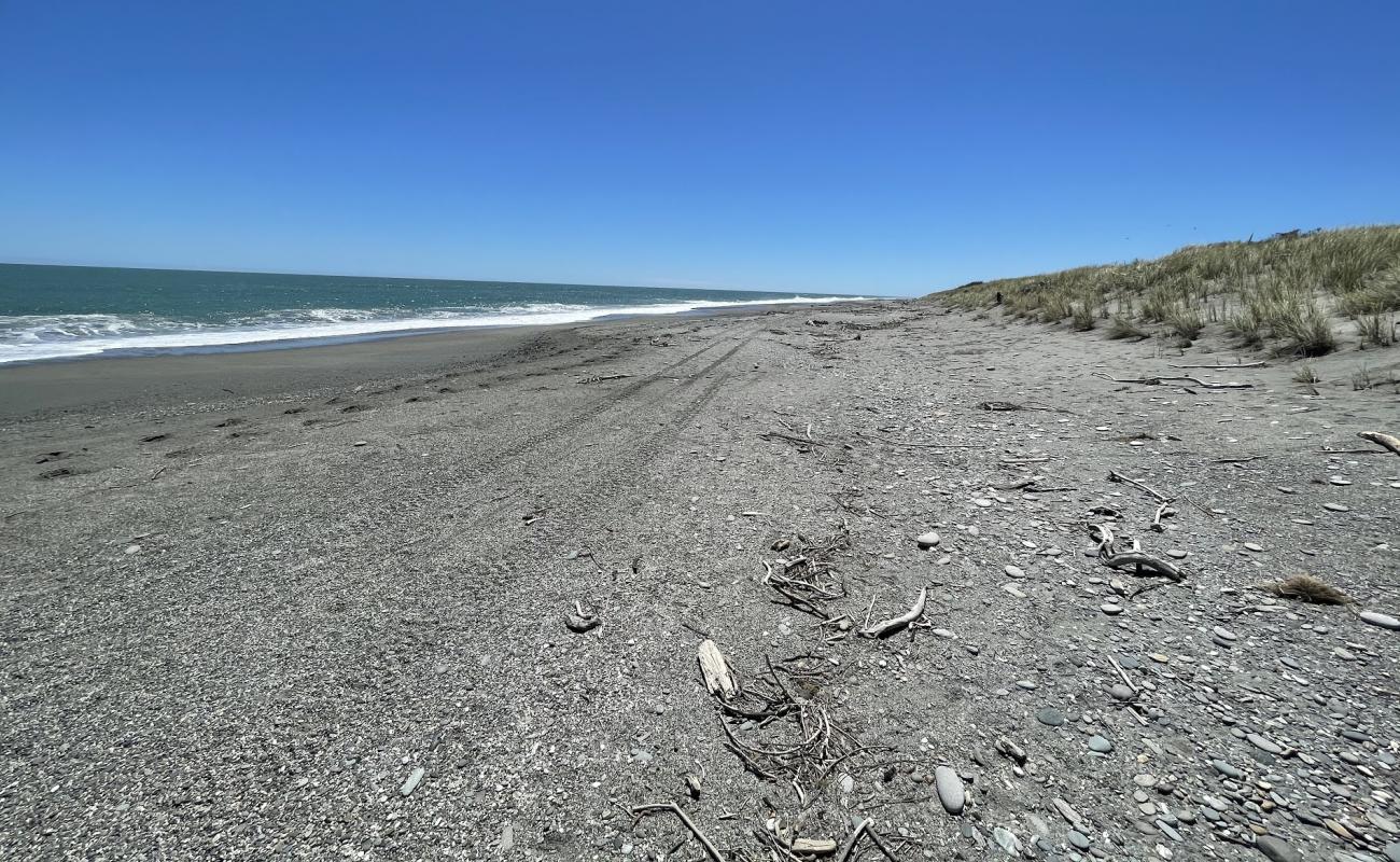 Mananui Beach'in fotoğrafı siyah kum ve çakıl yüzey ile