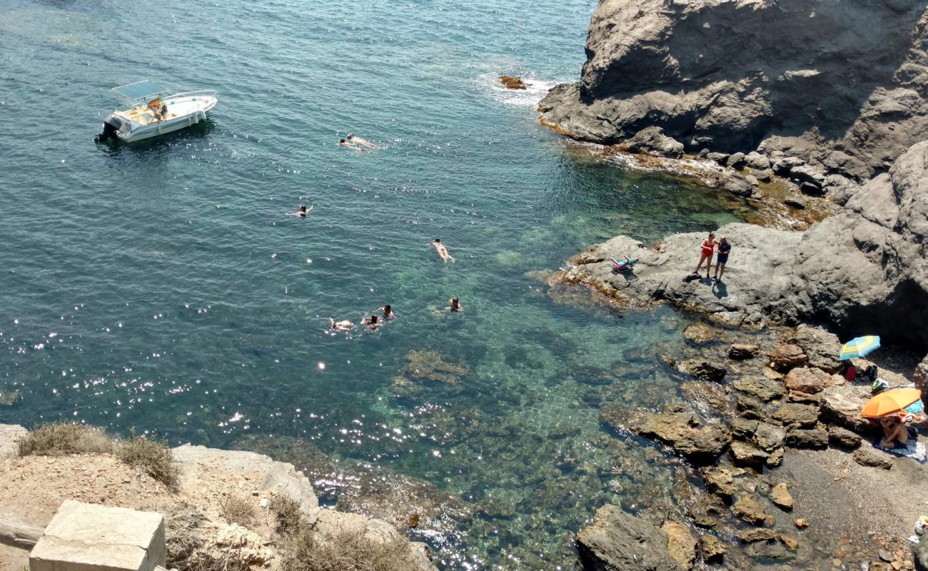 Cala de las Melvas'in fotoğrafı siyah kum ve çakıllar yüzey ile