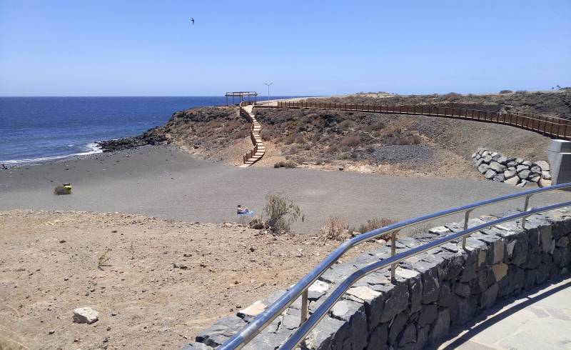 Playa Los Abrigos'in fotoğrafı kahverengi kum yüzey ile