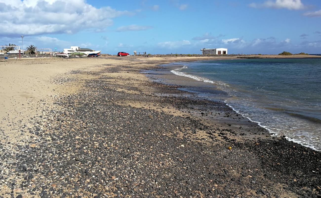 Playa del Muellito'in fotoğrafı siyah kum ve çakıllar yüzey ile