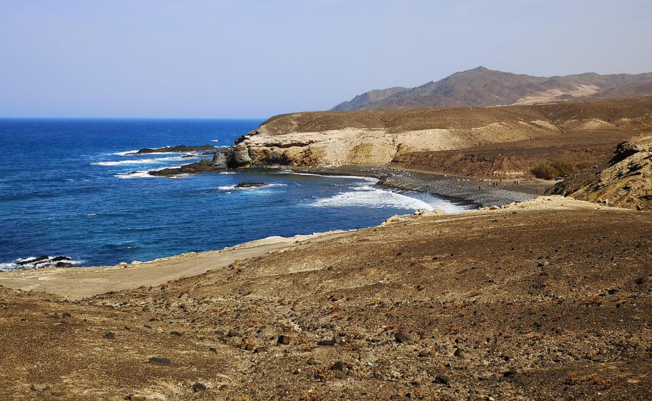 Playa de Ugan'in fotoğrafı taşlı kum yüzey ile